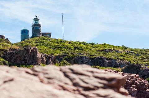Lighthouse on cliffs with blurred foreground of rocks sweden Stock Photos