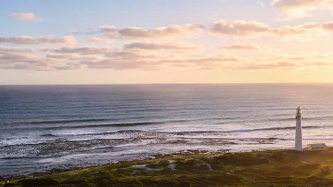 Lighthouse on Coastal Cliff at Ocean Sunset Stock Footage 313477209