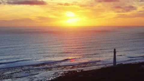 Lighthouse on Coastal Cliff at Ocean Sunset Stock Footage 313477435