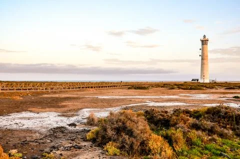A lighthouse is in the distance on a beach Stock Photos