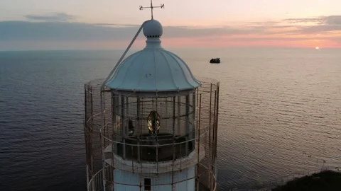 Lighthouse at dusk with magical sky. Lighthouse light spining around.  Stock Footage 163047762