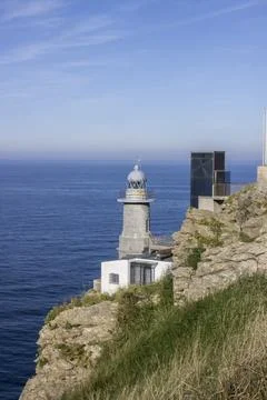 Lighthouse on the edge of a cliff by the ocean Stock Photos