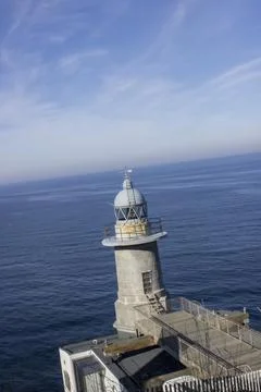 Lighthouse on the edge of a cliff by the ocean Stock Photos