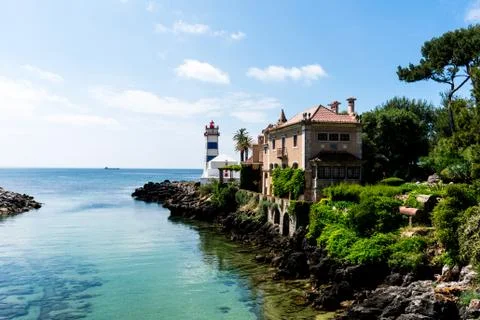 A lighthouse on the edge of some rocks Stock Photos