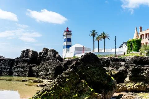 A lighthouse on the edge of some rocks Stock Photos