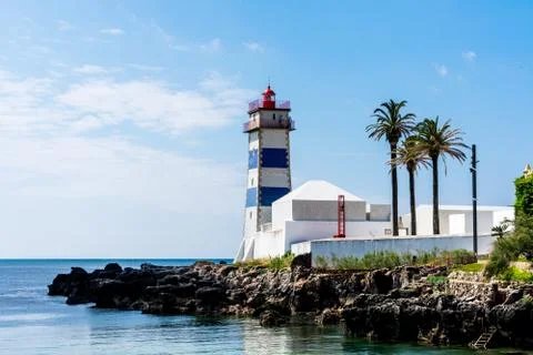 A lighthouse on the edge of some rocks Stock Photos