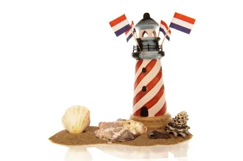 Lighthouse with flags and shells in sand Stock Photos