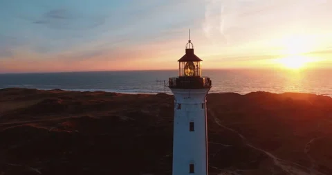 Lighthouse fly around sunset beach and ocean in the background aerial Stock Footage 153517797