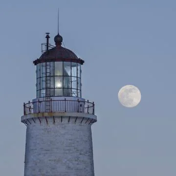 Lighthouse with full moon in the background. Stock Photos