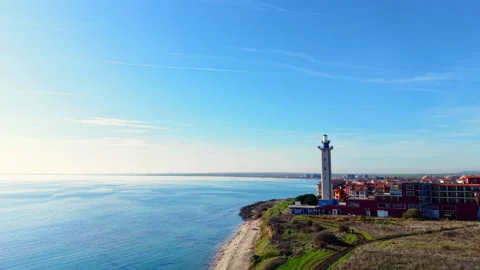 Lighthouse on grassy cliff by the sea. Video stock 326134428