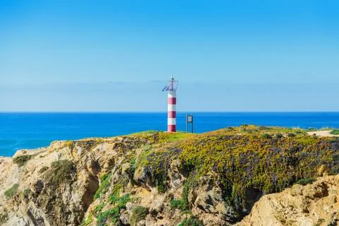 Lighthouse on the green rocks Stock Photos