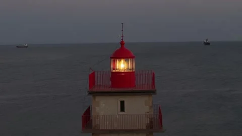 Lighthouse guiding ships at dusk over calm waters Stock Footage 282406555