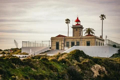 The lighthouse on the headland overlooking cliffs Stock Photos