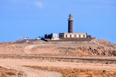 A lighthouse is on a hill overlooking a desert Foto stock