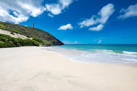 Lighthouse is on a hill overlooking the ocean Фото