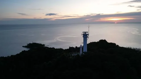 A lighthouse is on a hill overlooking the ocean at Segenting Видео 317006157