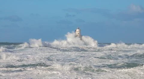 Lighthouse Hit by Ocean Waves During Storm Stock Photos