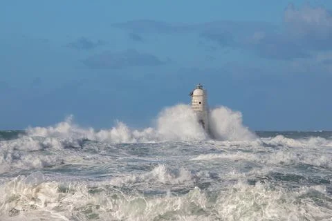 Lighthouse Hit by Ocean Waves During Storm Stock Photos