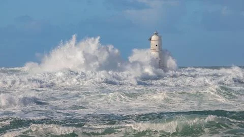 Lighthouse Hit by Ocean Waves During Storm Stock Photos