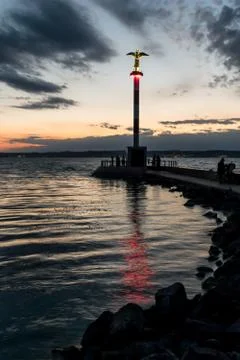 Lighthouse on lake at dusk. Stock Photos