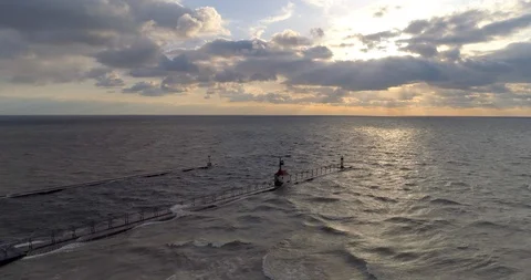 Lighthouse lake michigan with sunset pull back areial rise up dramatic storm Video stock 89512533