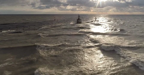 Lighthouse lake michigan with sunset pull back areial dolly in pan up 4K Video stock 89514581