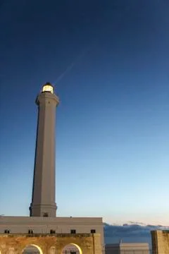 Lighthouse with light beam at sunset Stock Photos