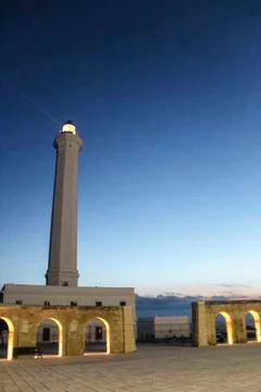 Lighthouse with light beam at sunset 库存照片