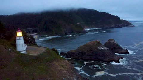 Lighthouse Light Lit Up Spinning Beam Shining Bright Over Pacific at Dusk Stock Footage 300283893