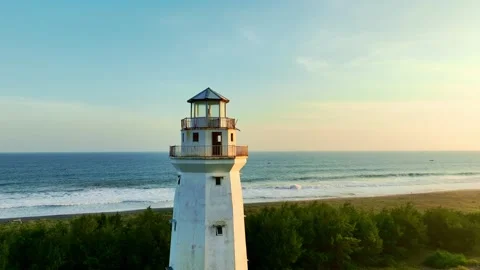 Lighthouse looking over ocean beach at sunset Video stock 335439848