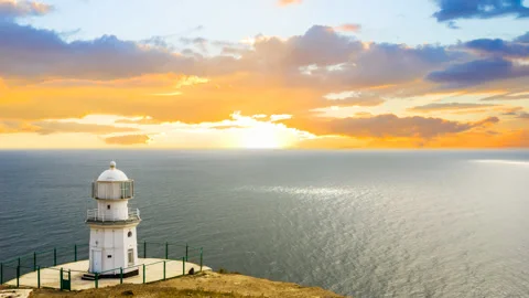 Lighthouse on a marine cape at the sunset Stock Footage 136720538