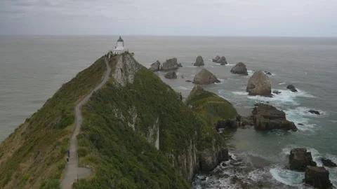 Lighthouse on a mountain overlooking the ocean with rocks, in New Zealand Stock Footage 219223383