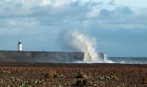 Lighthouse at Newhaven with waves breaking over harbour arm. Stock Photos