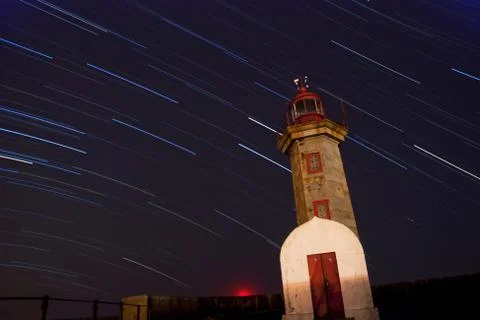 Lighthouse at night with startrails Stock Photos