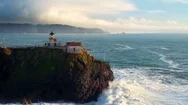 Lighthouse Overlooking Giant Ocean Waves By Aerial Drone Stock Footage