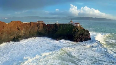 Lighthouse overlooking giant ocean waves by Aerial Drone Stock Footage 70398992