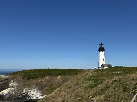 A lighthouse on the Pacific coast against a clear blue sky Stock Photos