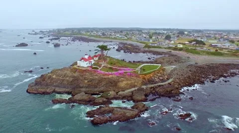 A lighthouse in the Pacific northwest surrounded by blooming pink flowers Stock-Footage 52132822