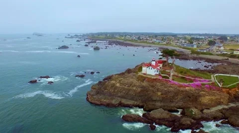 A lighthouse in the Pacific northwest surrounded by blooming pink flowers Stock Footage 52134674