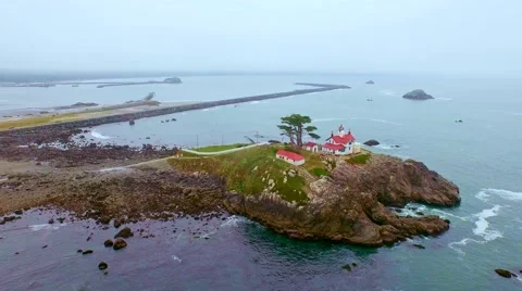 A lighthouse in the Pacific northwest surrounded by blooming pink flowers Stock-Footage 52138178