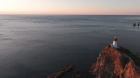 Lighthouse Perched on Cliff Overlooking Ocean Stock Footage 266928748