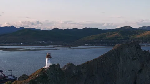 Lighthouse Perched on Rocky Outcropping Overlooking Water 動画素材 266936100