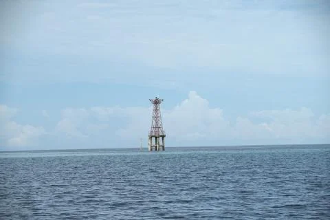 A lighthouse is on a pier in the ocean Stock Photos