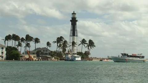 Lighthouse Point-Florida-wide shot-lighthouse-tour boat passes-palm trees Stock Footage 115091571