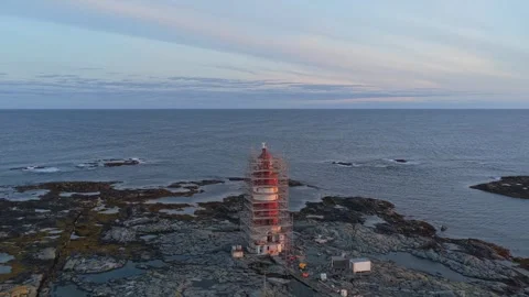 Lighthouse repair work in progress at dawn, Veiholmen, Norway aerial Stock Footage 320499509