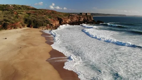 Lighthouse on the rock near long beach coast of Atlantic sea with big waves. Stock Footage 247501988