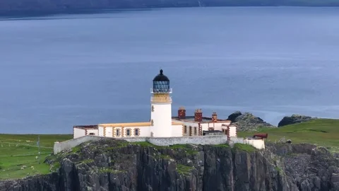 A lighthouse is on a rocky cliff overlooking the ocean Stock Footage 306641885