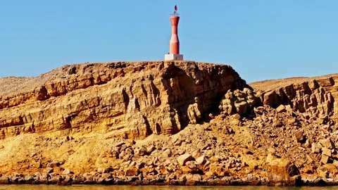 Lighthouse on rocky cliffs in Sharm El Sheikh under clear blue sky 스톡 동영상 332629234
