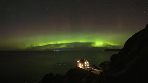Lighthouse on rocky coast with aurora Stock Footage 269701442
