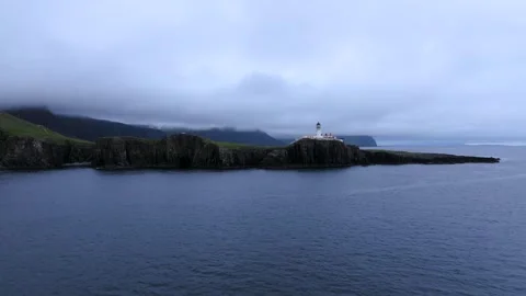 A lighthouse is on a rocky shore Stock Footage 306619456